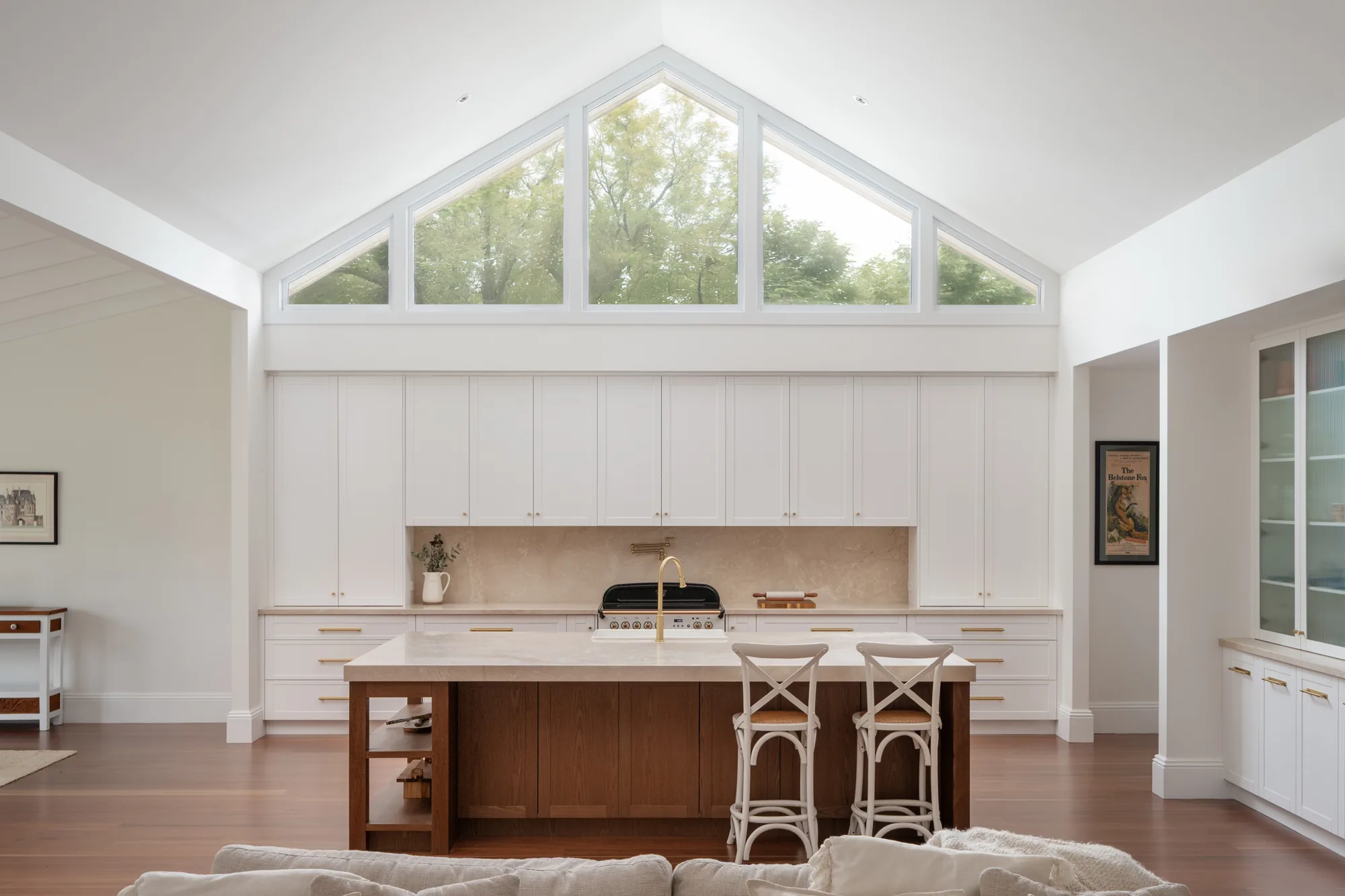 Hamptons kitchen with cream stone benchtops and brass tapware at Bolwarra