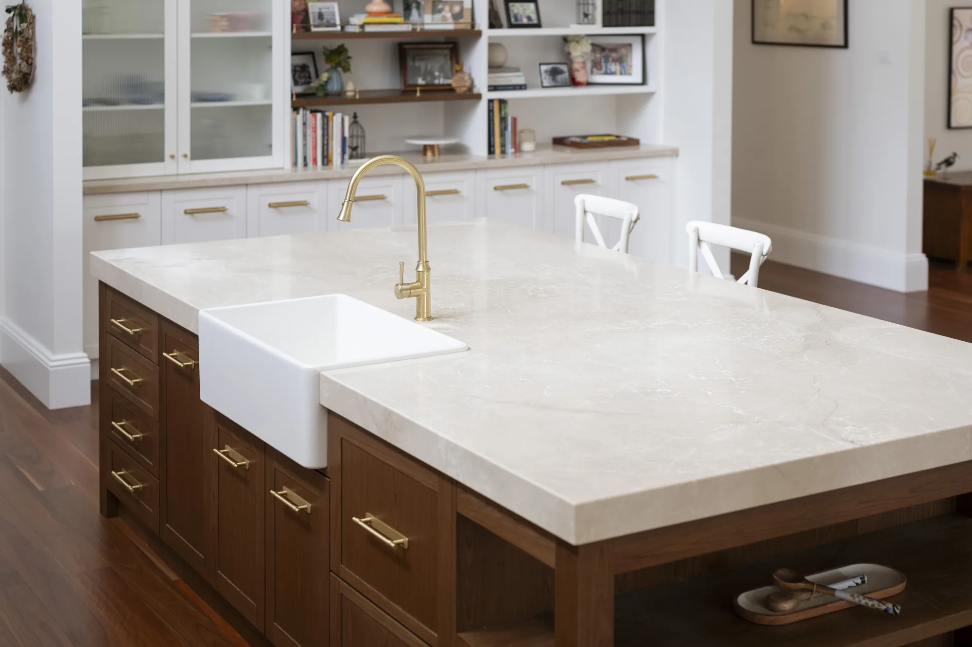 Cream stone island benchtop with brass tapware, fabricated and installed by Tops In Stone at Bolwarra