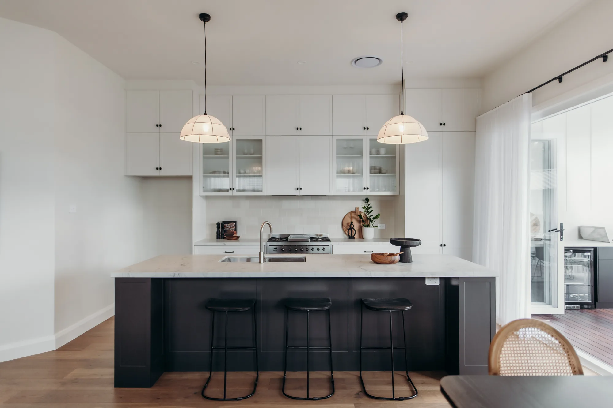Black island with brushed white stone benchtop in a Mayfield kitchen