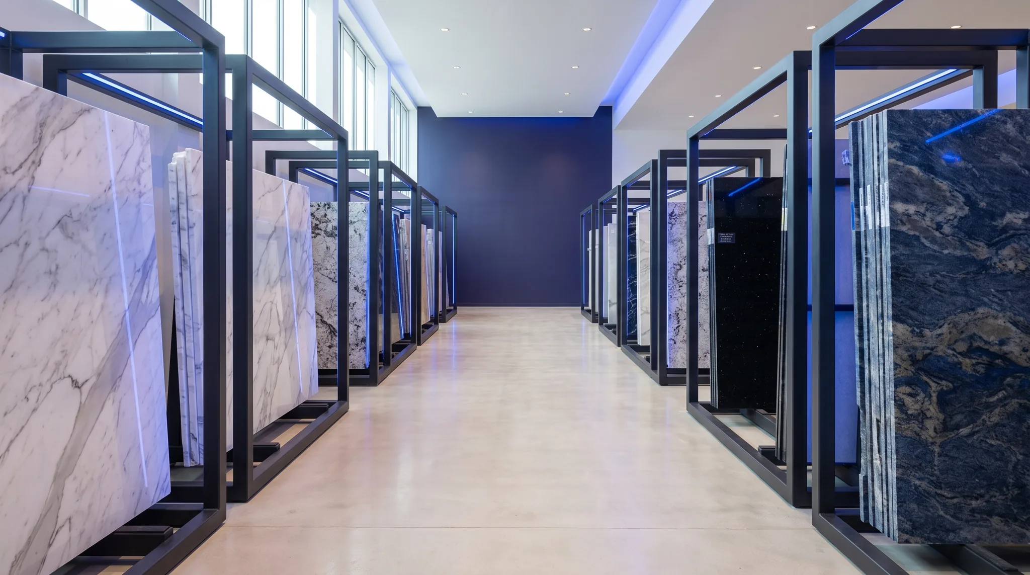Stone slabs standing in display racks in a showroom aisle